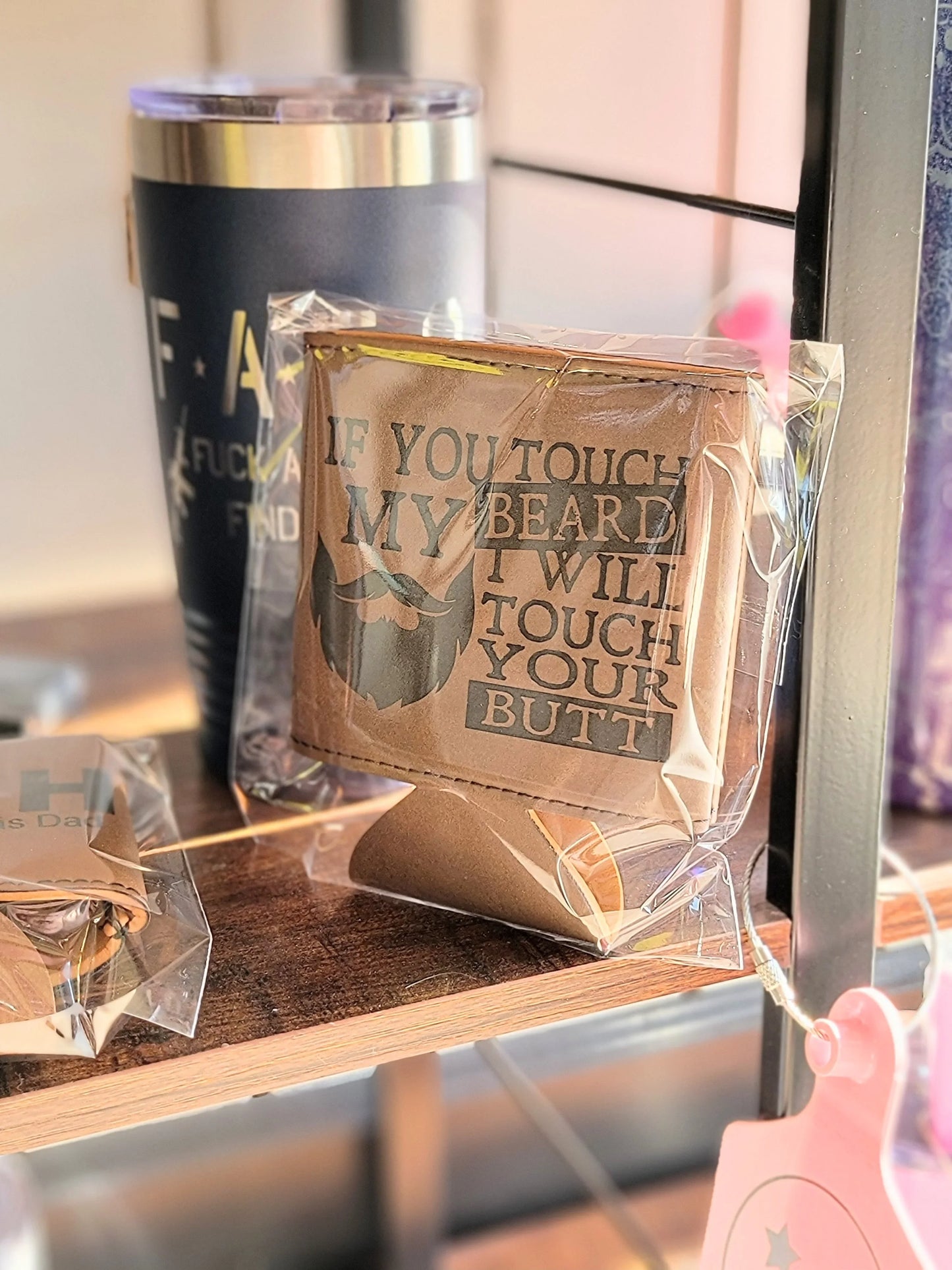 Laser engraved leather can cooler with beard quote, novelty personalized gift on display shelf