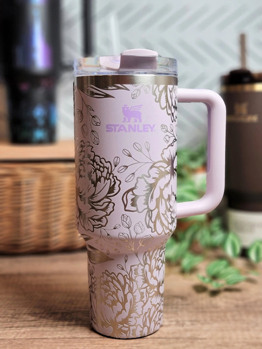 Pink floral engraved Stanley tumbler with handle on a wooden table — custom drinkware care guide from The Burn Shack, Denair CA