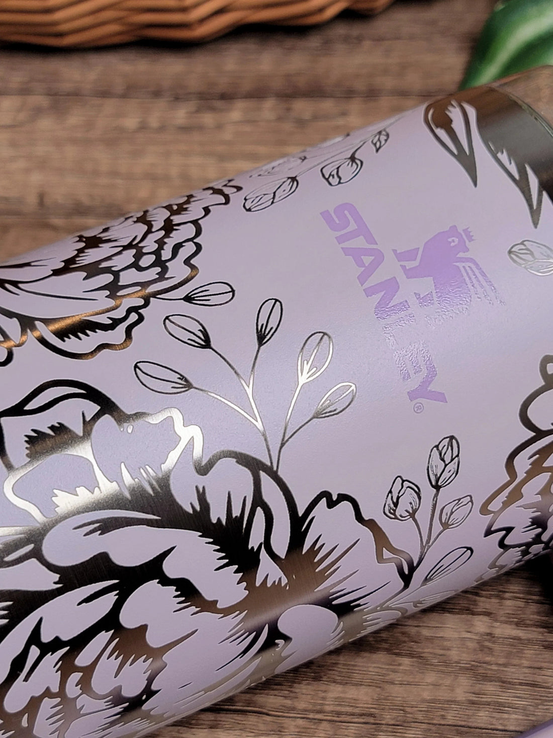 Lilac Stanley tumbler with metallic floral engraving on wood background — multi-material laser engraving samples from The Burn Shack, Denair CA