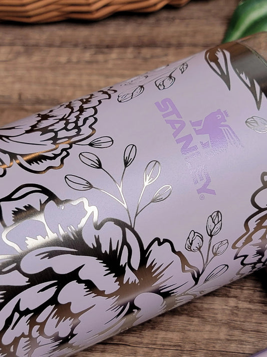 Lilac Stanley tumbler with metallic floral engraving on wood background — multi-material laser engraving samples from The Burn Shack, Denair CA