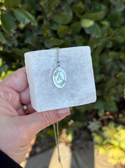 Oval charm necklace layered with other jewelry
