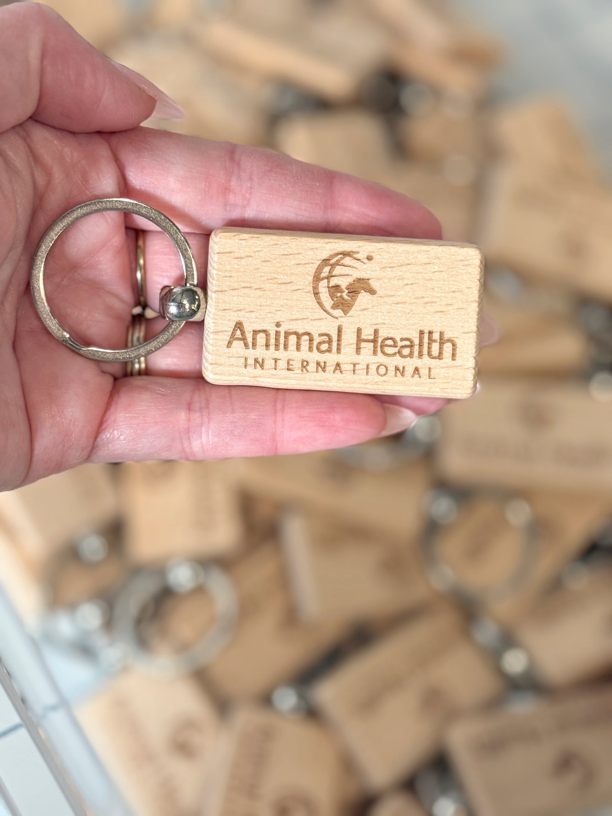 Single laser-engraved wood keychain — custom branded promotional product by The Burn Shack, Denair CA